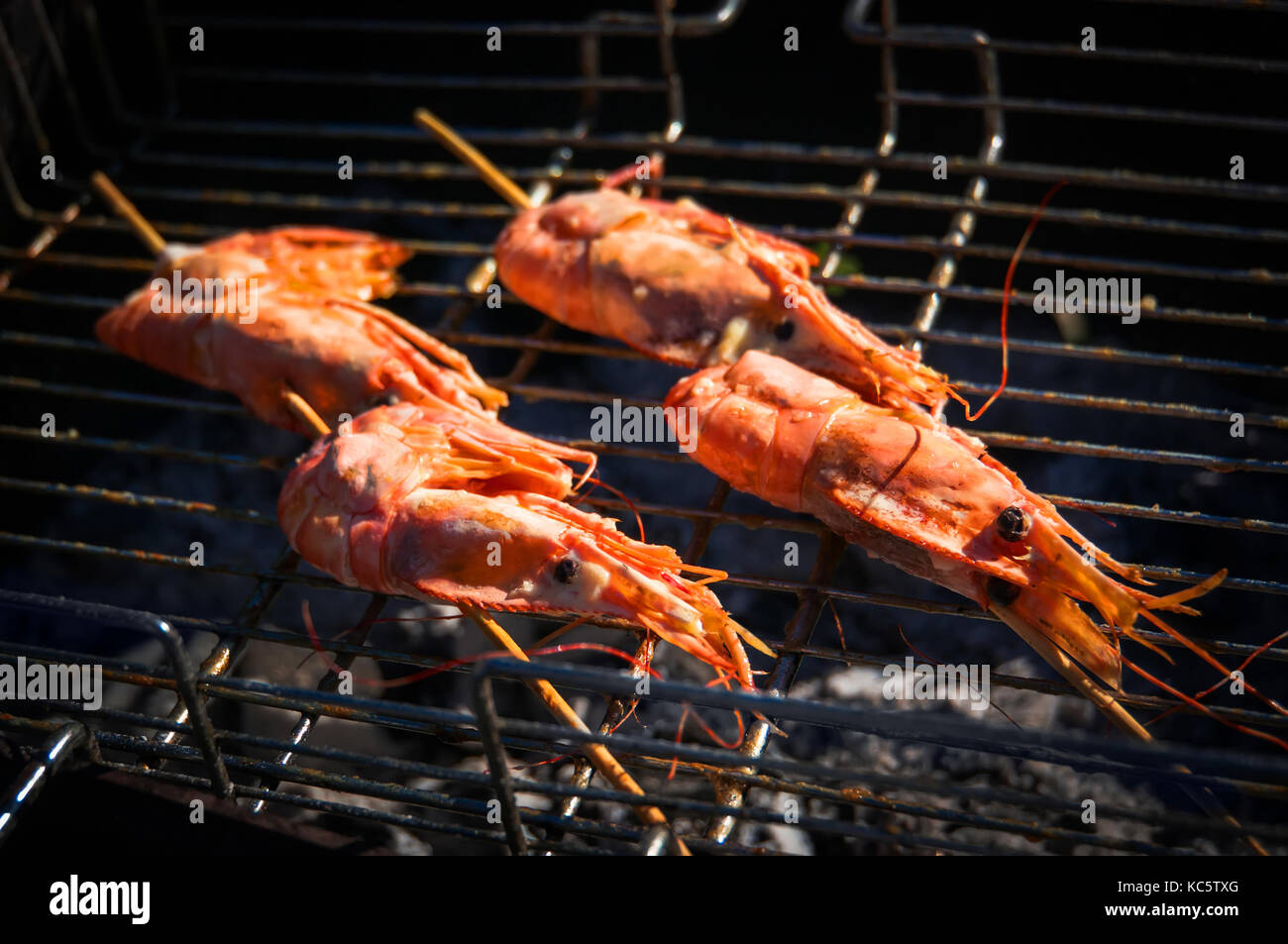 delicious prawn spit on grill with flames. King prawns in the shell fried  in the fire Stock Photo - Alamy