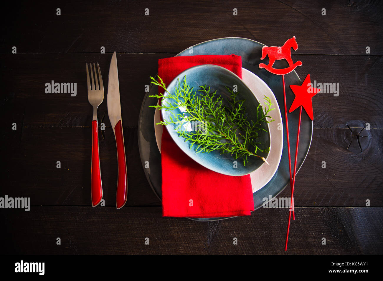 Festive table setting for Christmas dinner on dark rustic table with
