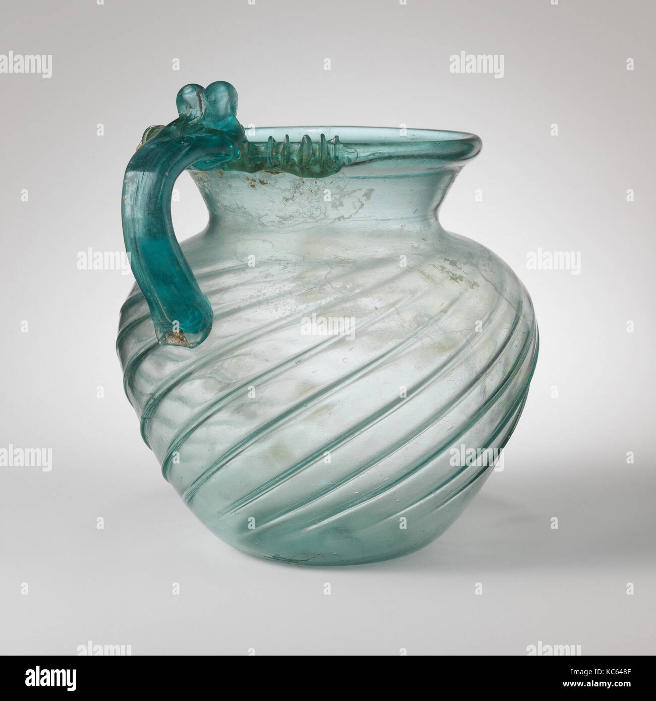 Glass jug, Early to Mid Imperial, late 1st–2nd century A.D., Roman, Glass; blown in a dip mold and tooled, Height: 7 15/16 in Stock Photo