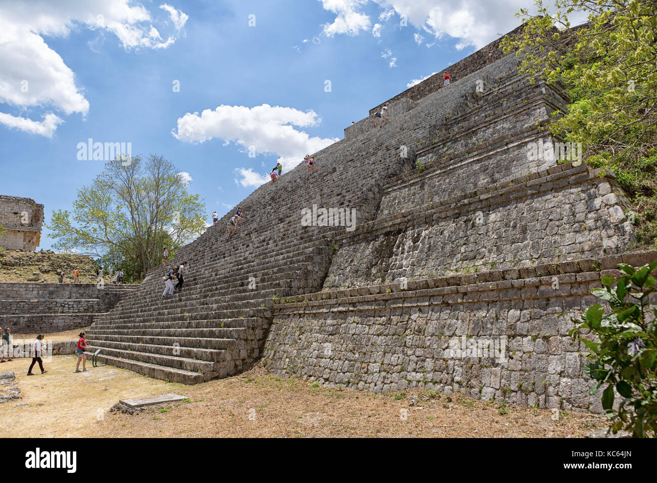 April 23, 2014 Uxmal, Mexico: tourists climb the steep stairs of a pyramid at the UNESCO World Heritage site Stock Photo