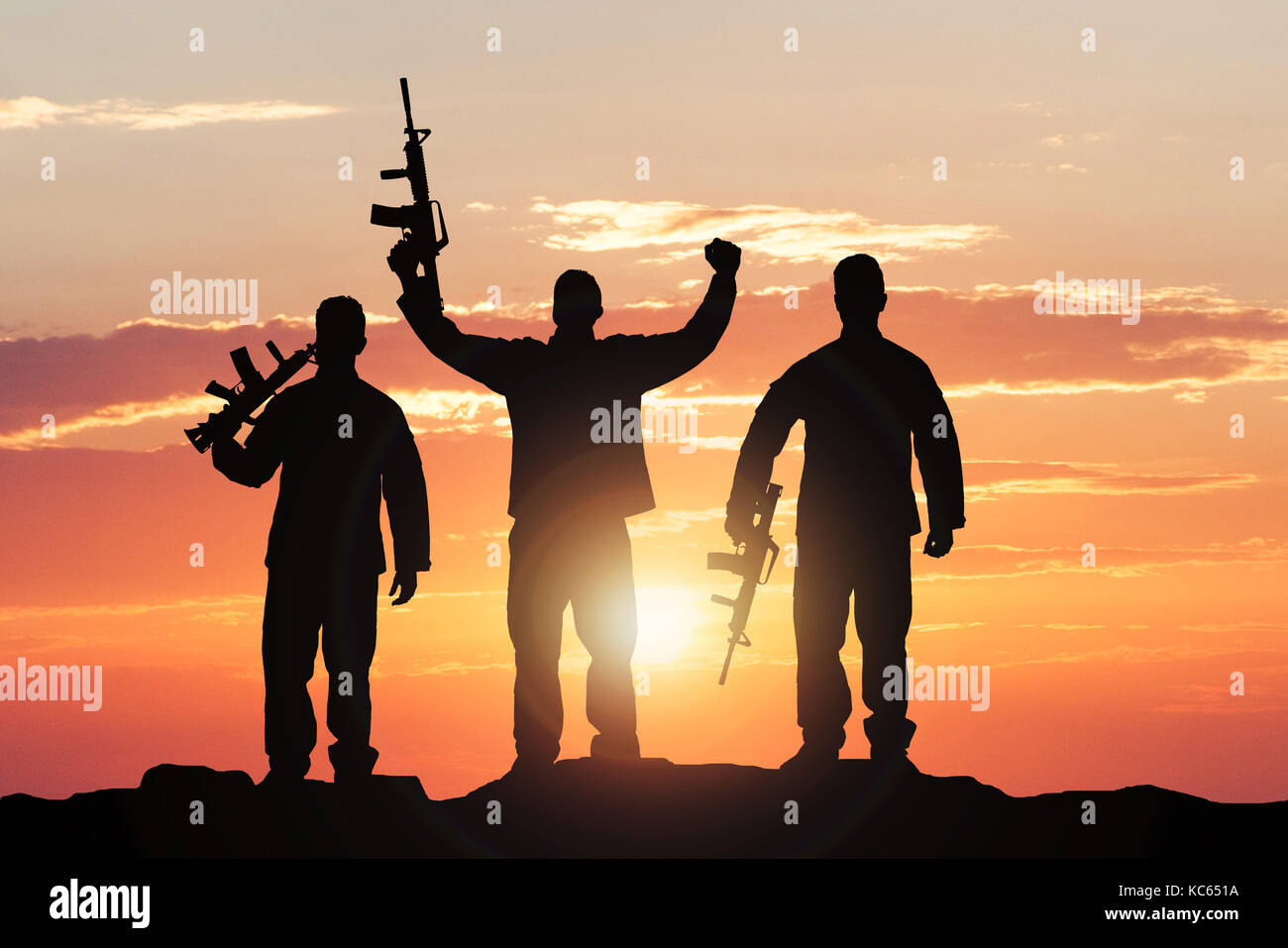 Silhouette Of Soldiers With Rifles Against Dramatic Sky Stock Photo