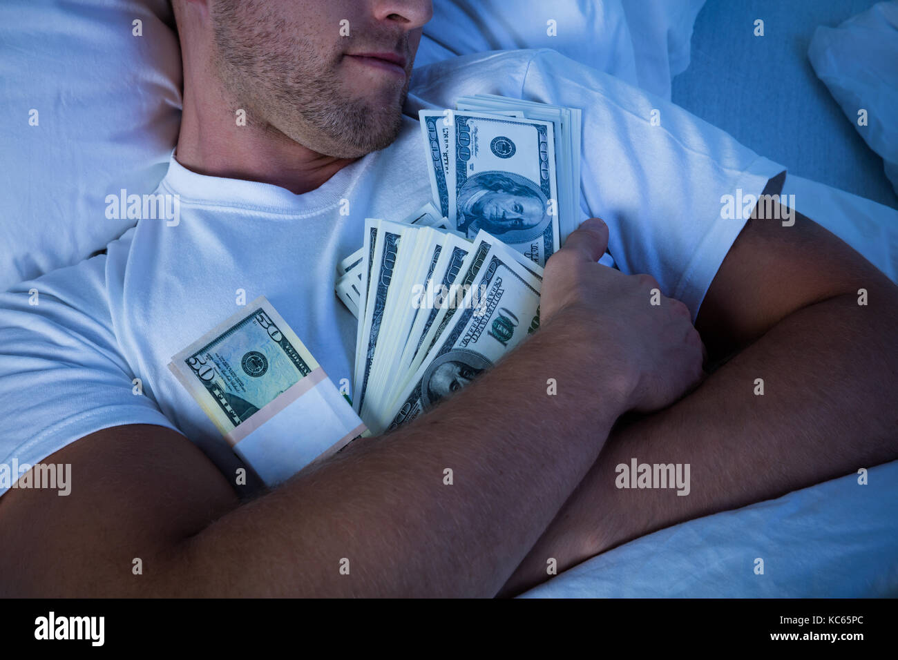 Man Sleeping On Bed With Bundle Of Currency Notes Stock Photo