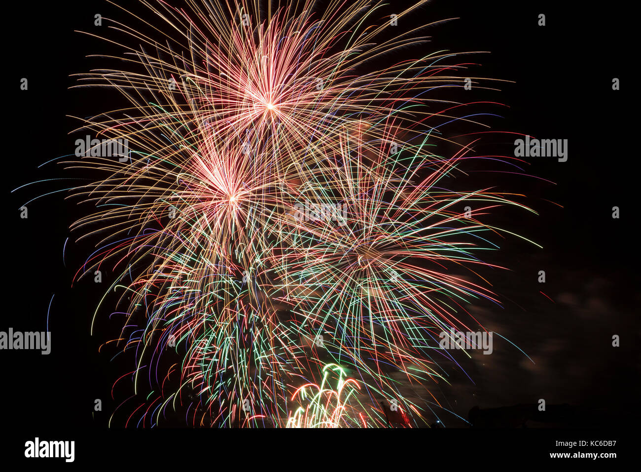 Bright colorful fireworks display in a night sky conceptual of a celebration, carnival, festival, 4th July, New Year, Guy Fawkes or party event. This  Stock Photo