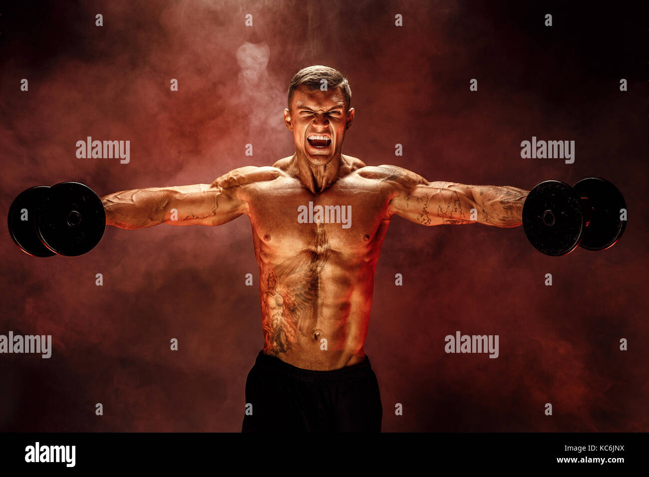 very brawny guy bodybuilder, execute exercise with dumbbells, on deltoid muscle shoulder Stock Photo