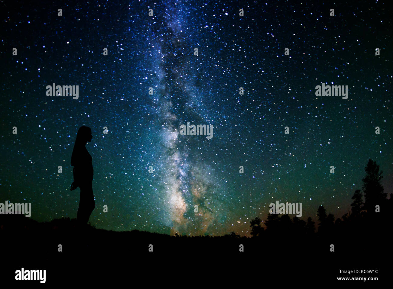 Silhouette of woman against Milky Way Stock Photo