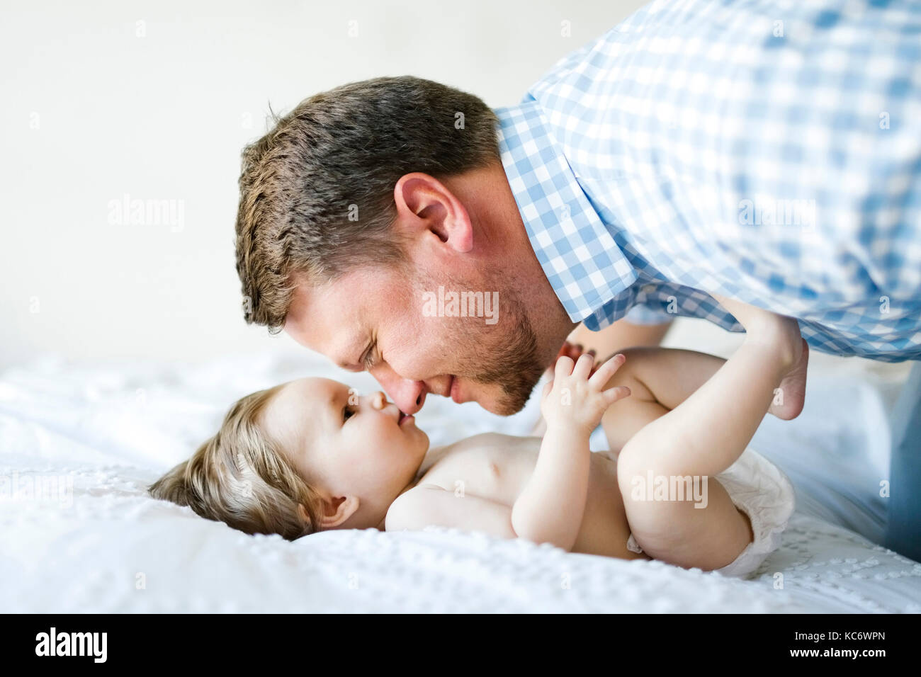 Baby girl (6-11 Months) with father face to face Stock Photo