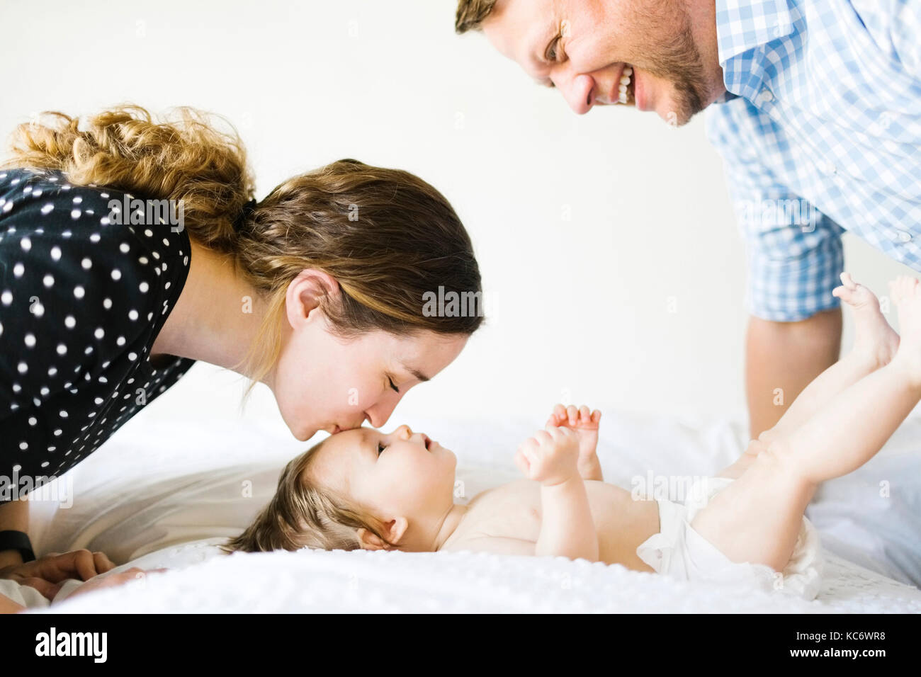 Baby girl (6-11 Months) spending time with parents Stock Photo