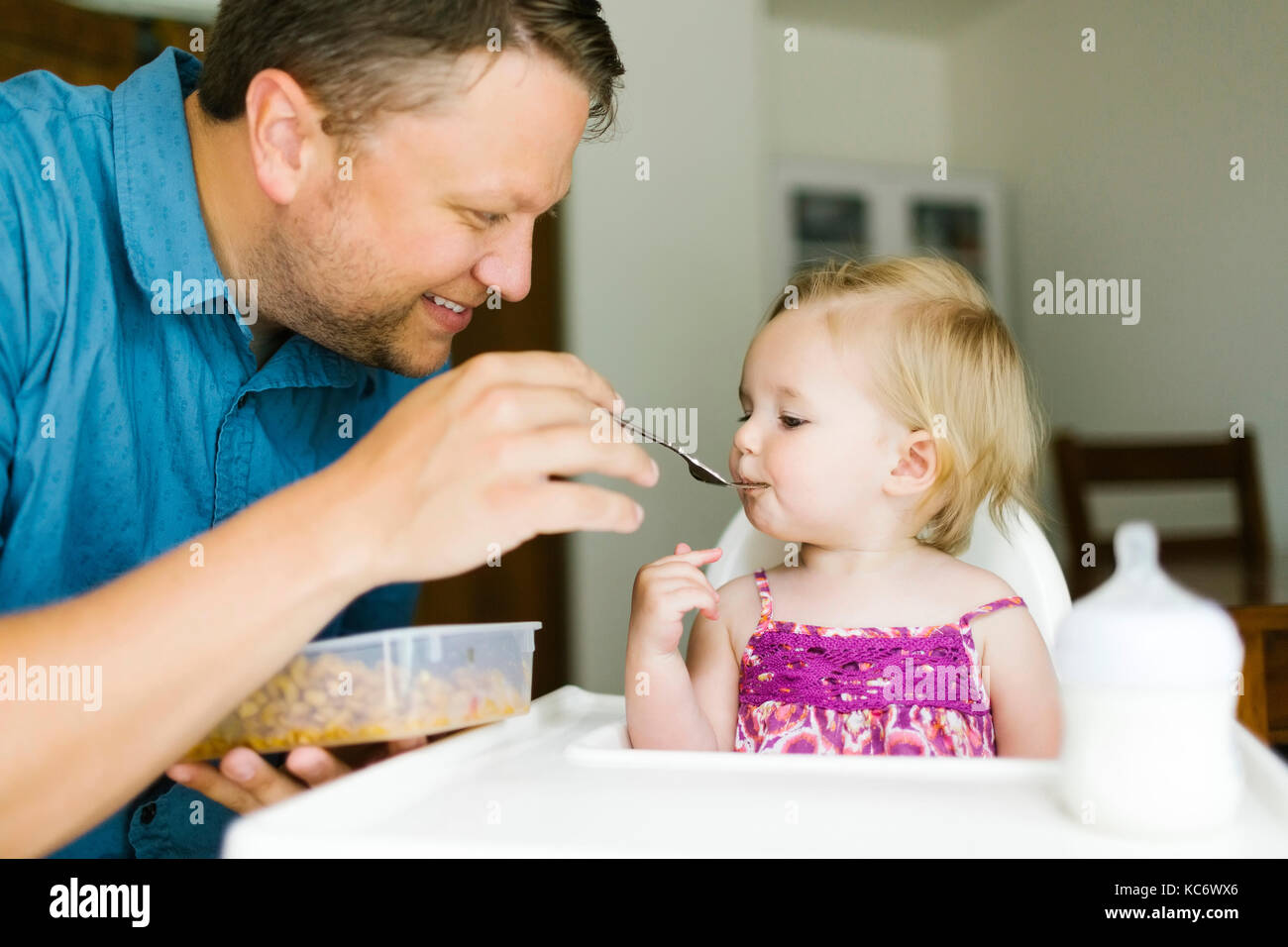 Father feeding baby girl (12-17 months) Stock Photo