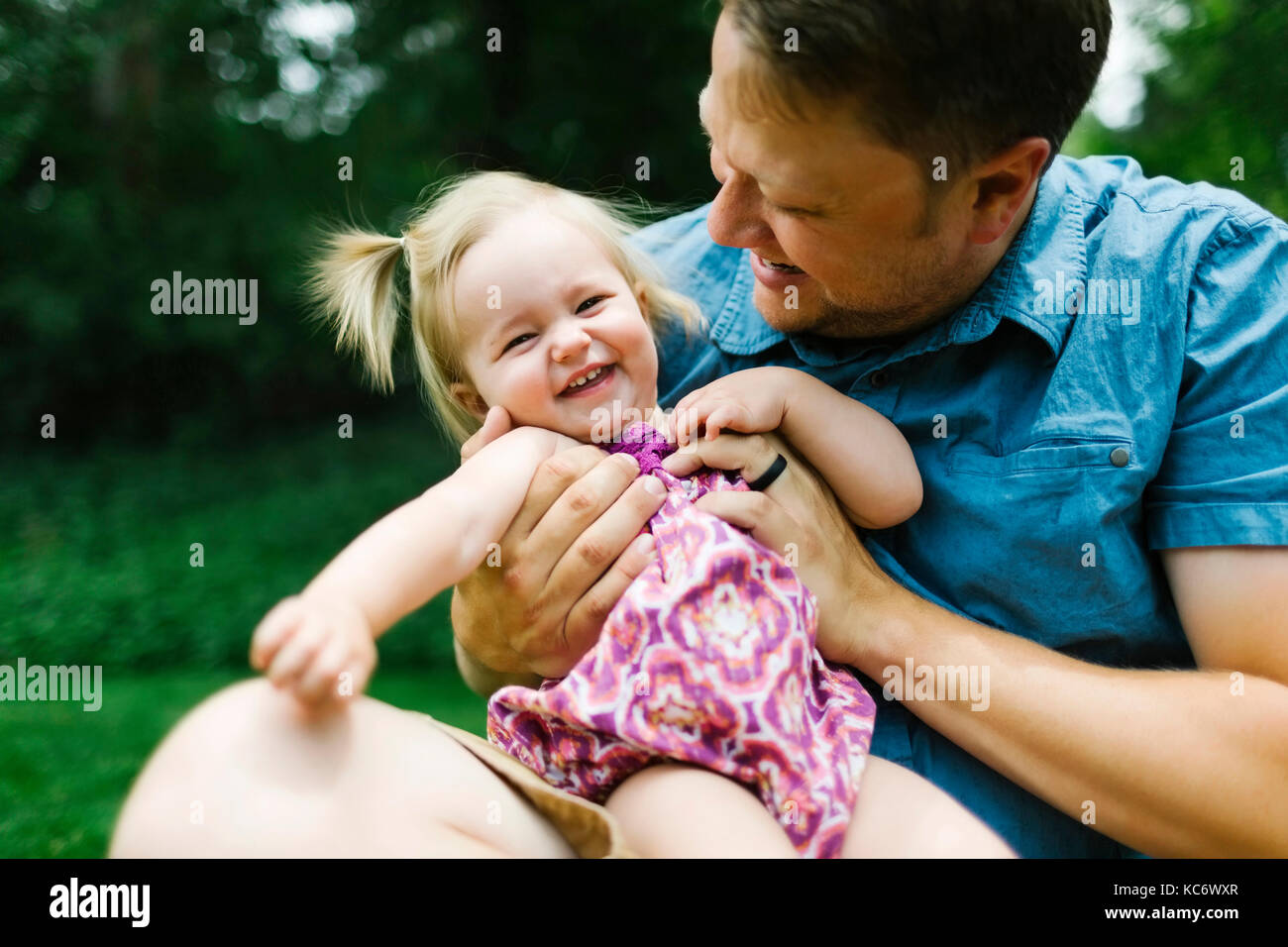 Father playing with baby girl (12-17 months) in backyard Stock Photo