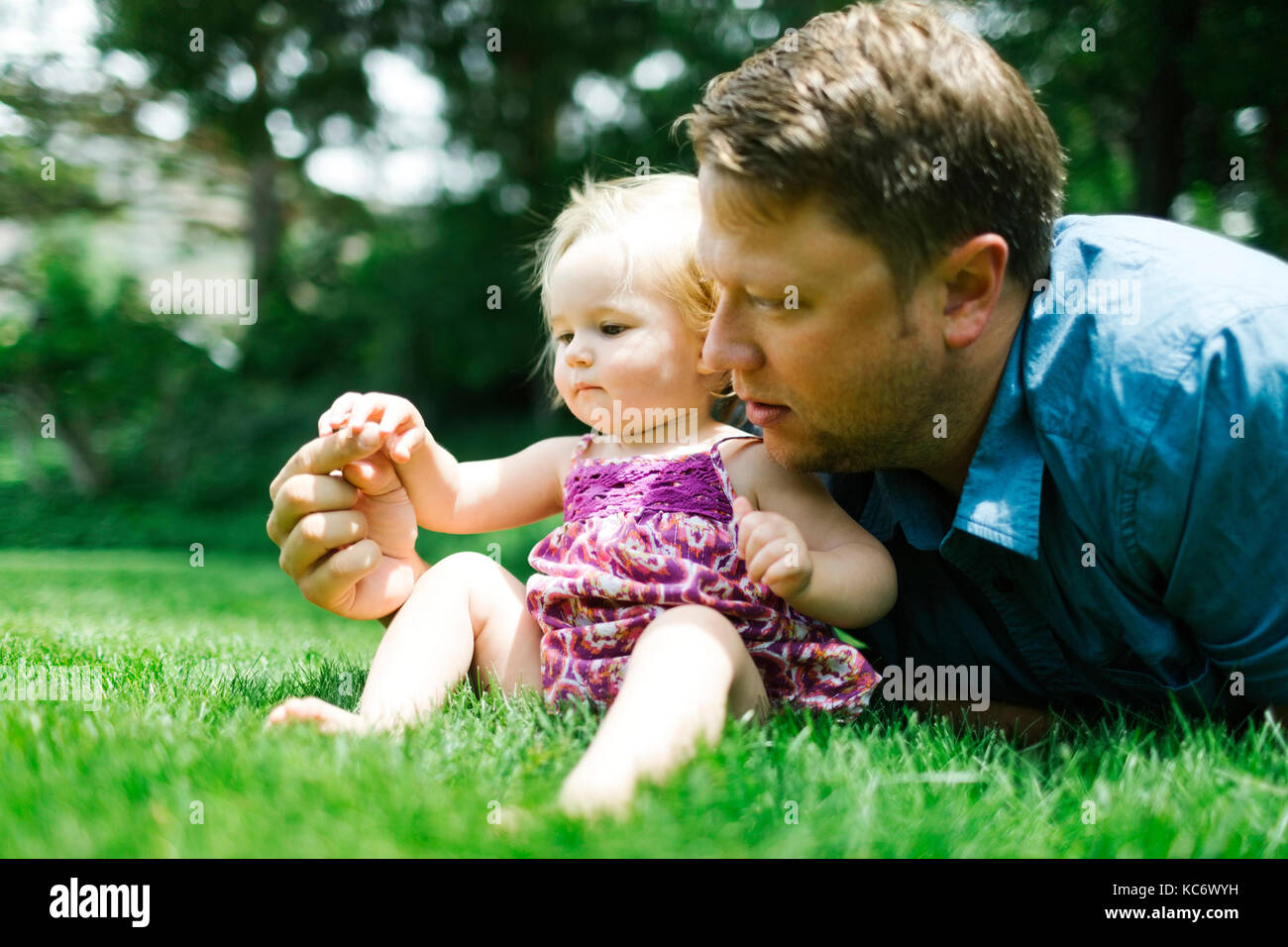 Father playing with baby girl (12-17 months) in backyard Stock Photo