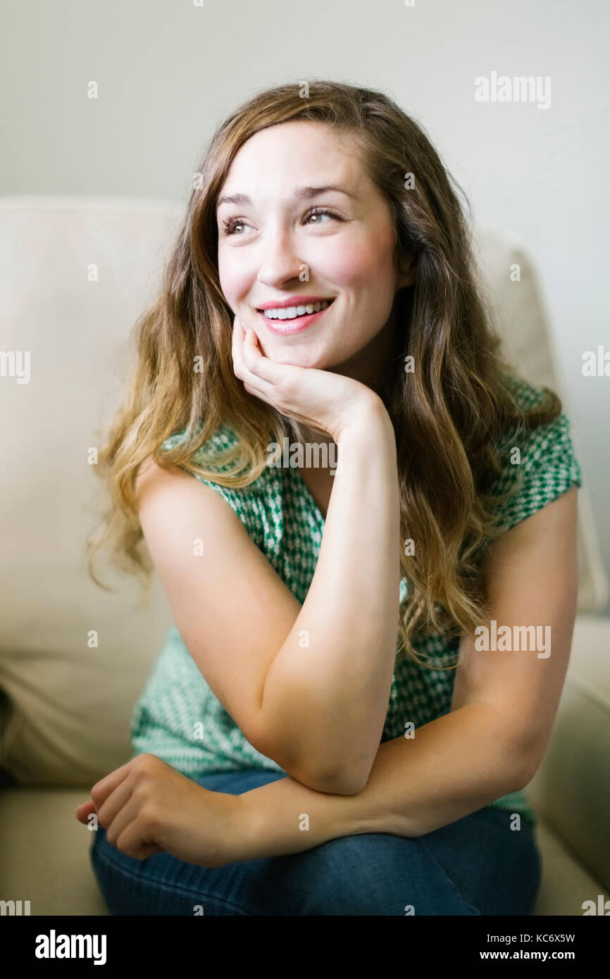 Portrait of woman sitting in living room Stock Photo