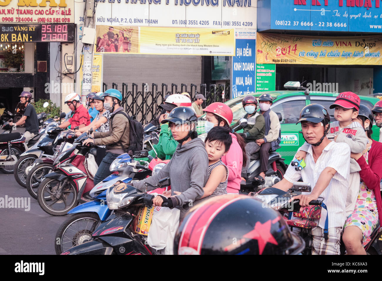 Saigon, Vietnam - January 2017: Many scooter driver and motorbikes at traffic light on Saigon street. Stock Photo