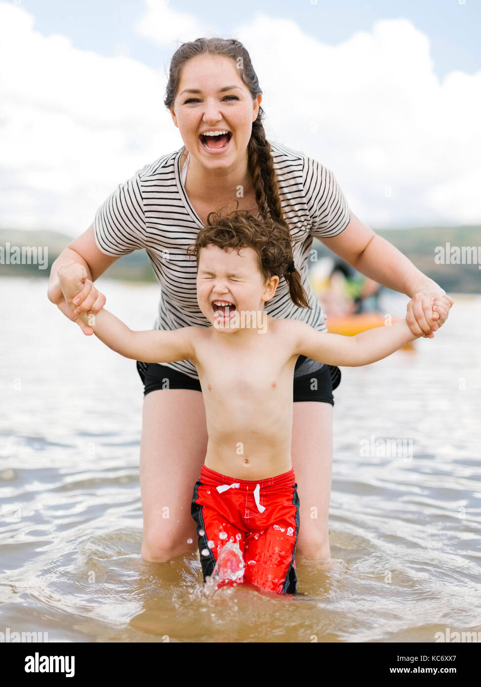 Mother playing with son (4-5) in lake Stock Photo