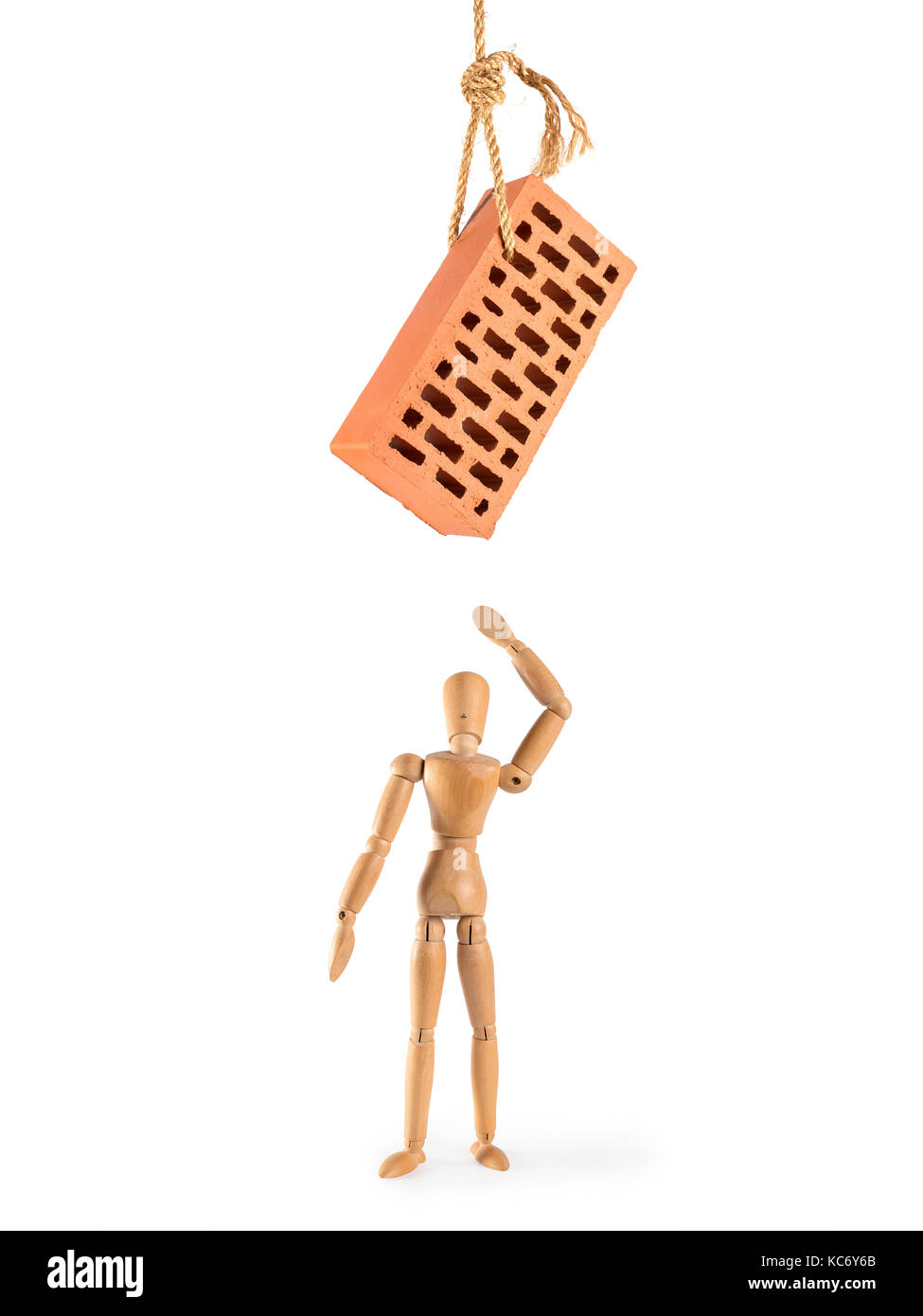 Wooden man with hanging brick threatening him. Isolated on white. Danger, threat, force majeure, disaster and accident concept. Stock Photo
