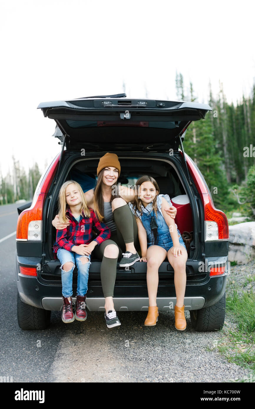 Portrait of woman with son (6-7) and daughter (8-9) in back of car Stock Photo