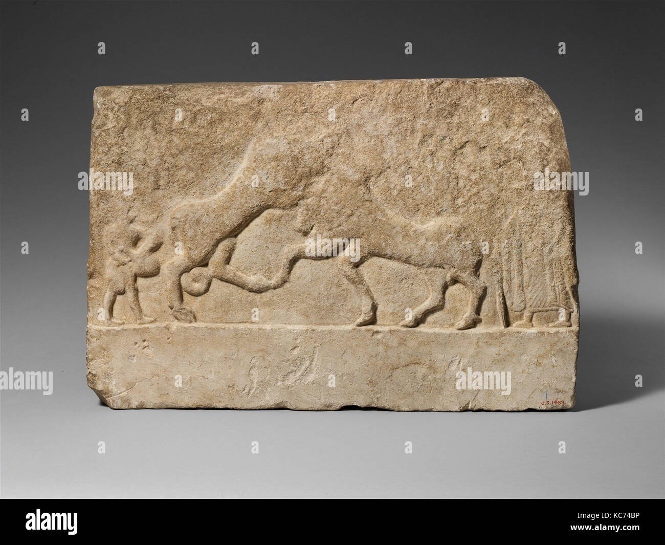 Limestone votive relief with a lion killing a bull and two human figures, 2nd half of the 6th century B.C Stock Photo