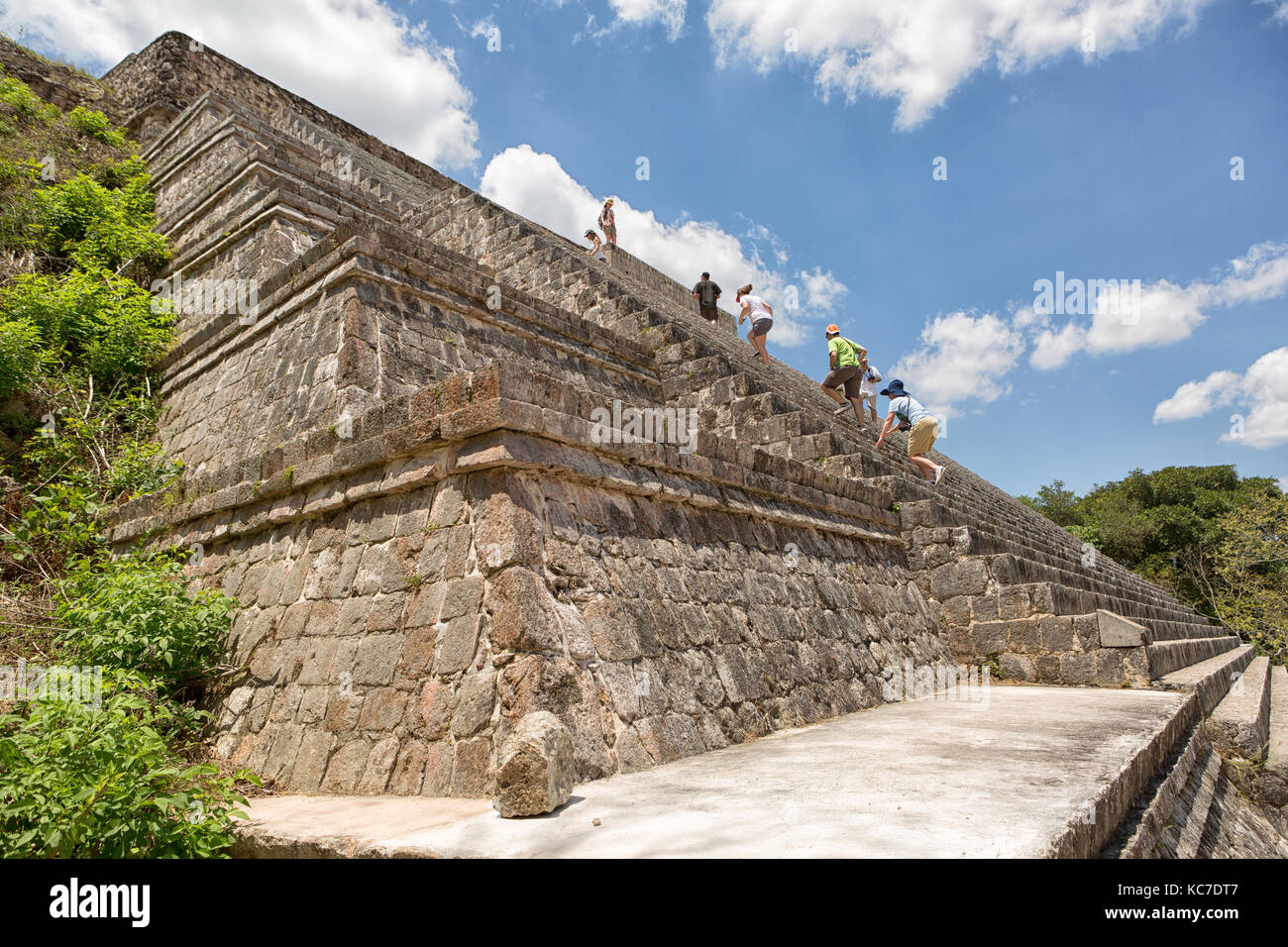 April 23, 2014 Uxmal, Mexico: tourists climb the steep stairs of a pyramid at the UNESCO World Heritage site Stock Photo