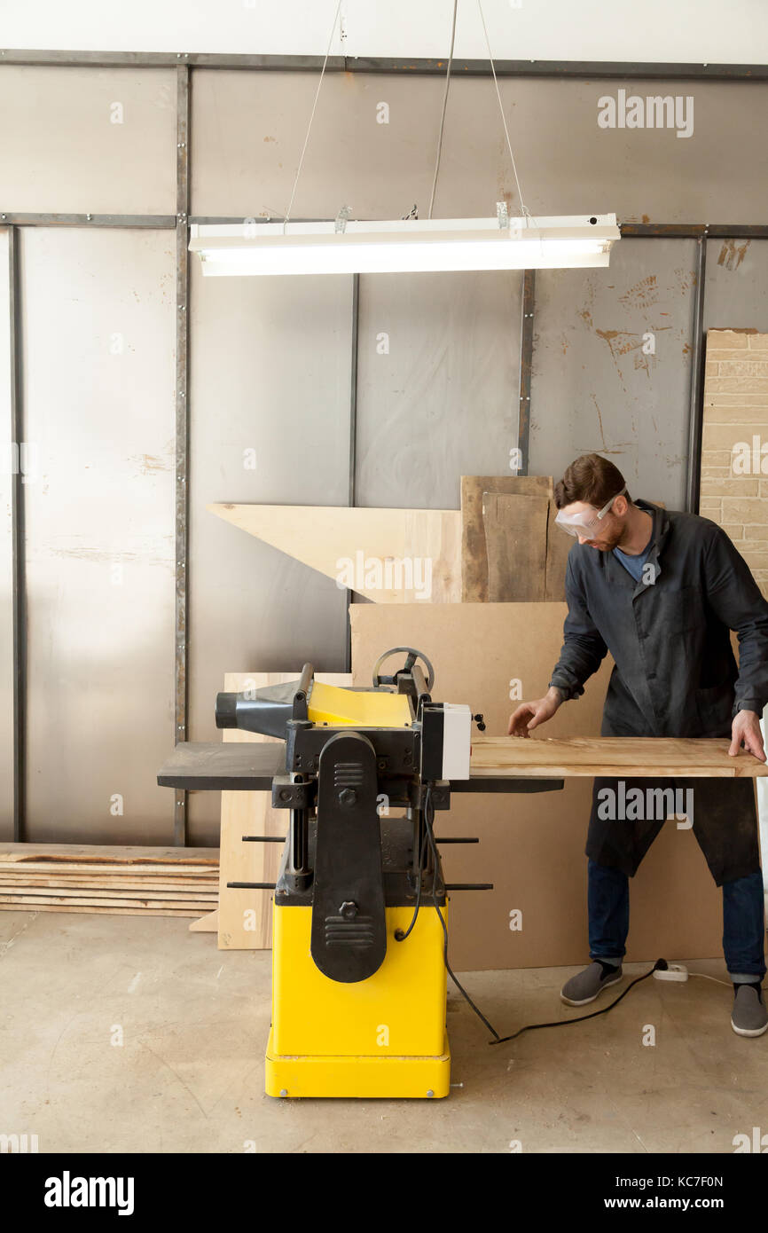 Skilled carpenter working at machine tool Stock Photo