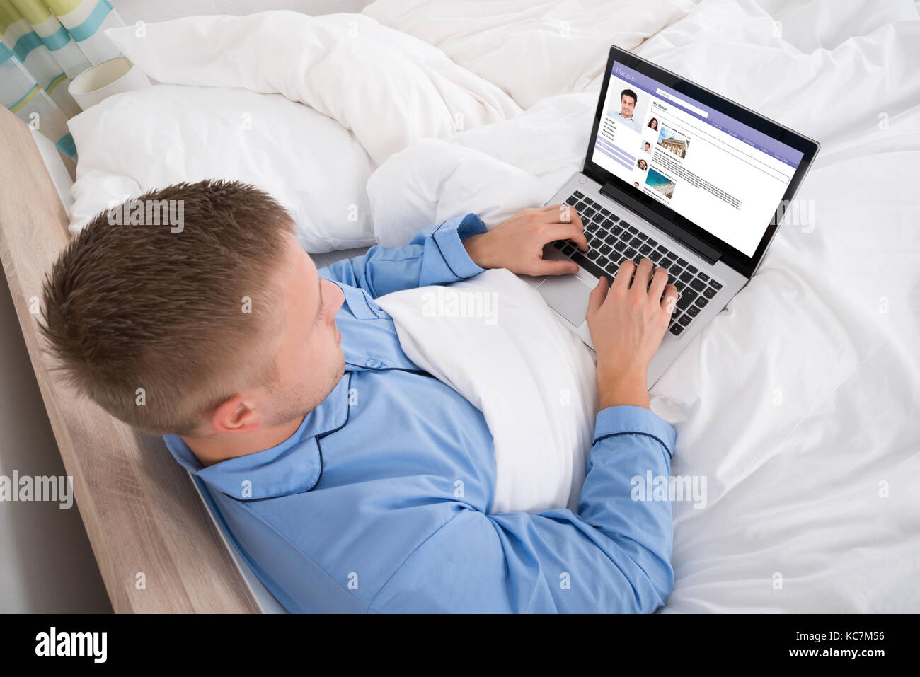 Young Man Chatting On Social Networking Site Using Laptop Stock Photo
