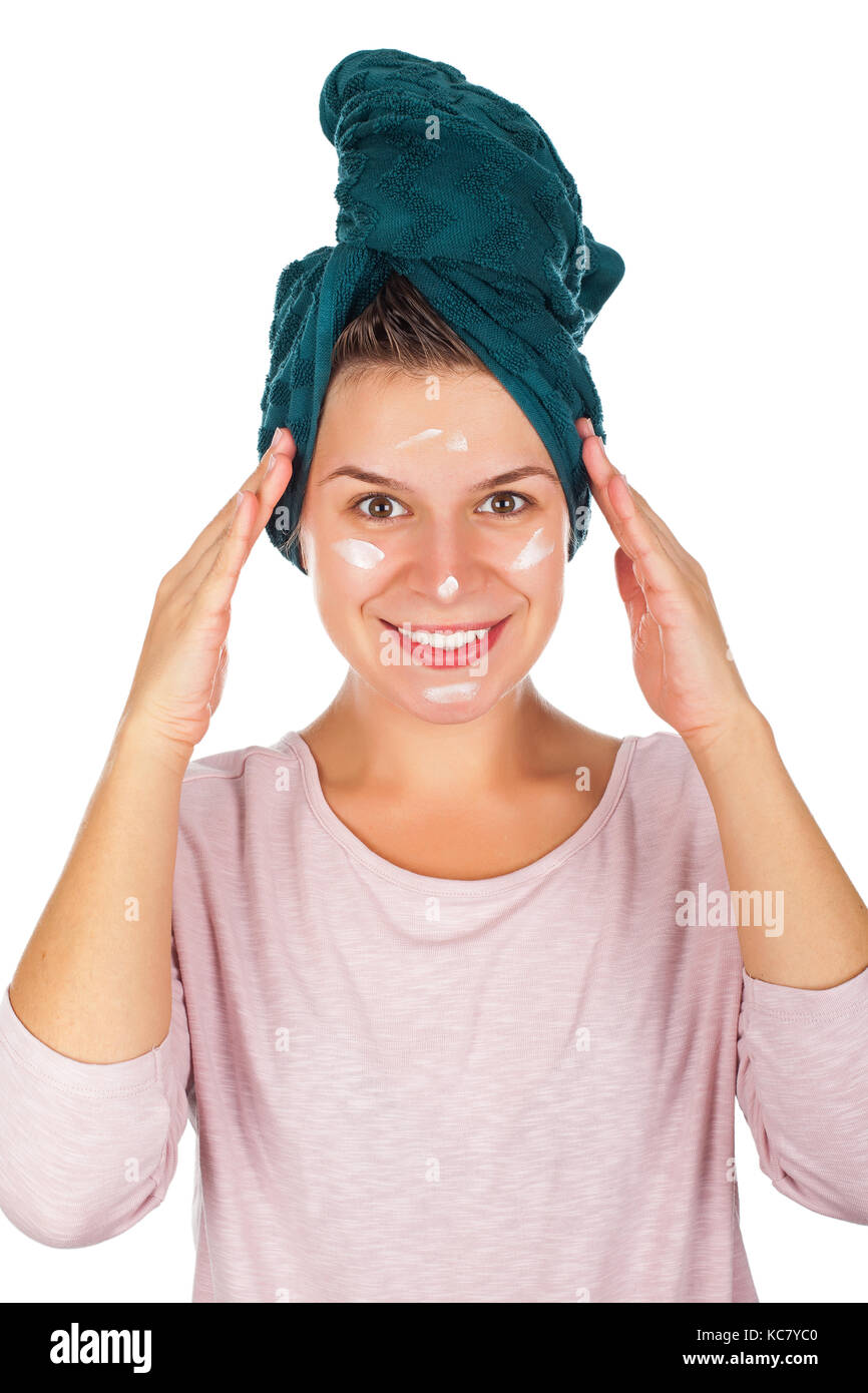Beautiful young woman after shower with towel on head applying face