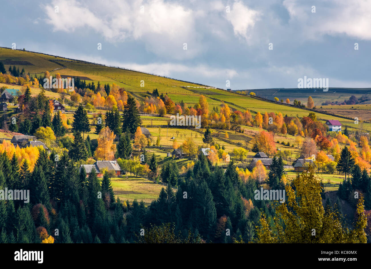 village on hillsides in mountains. beautiful countryside scenery with yellow trees Stock Photo
