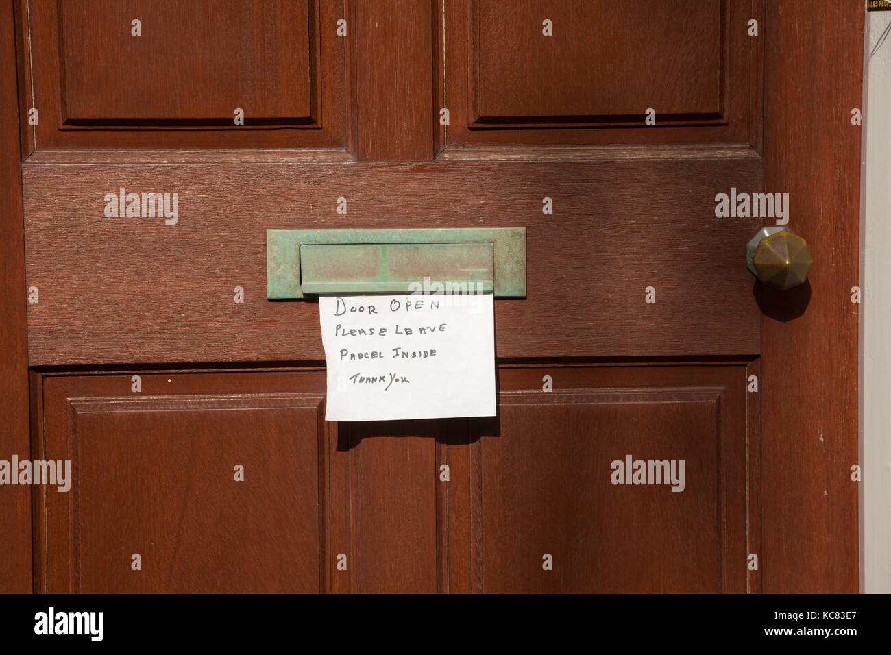 A note stuck to a door in Fife saying it's open please leave parcel inside. Stock Photo