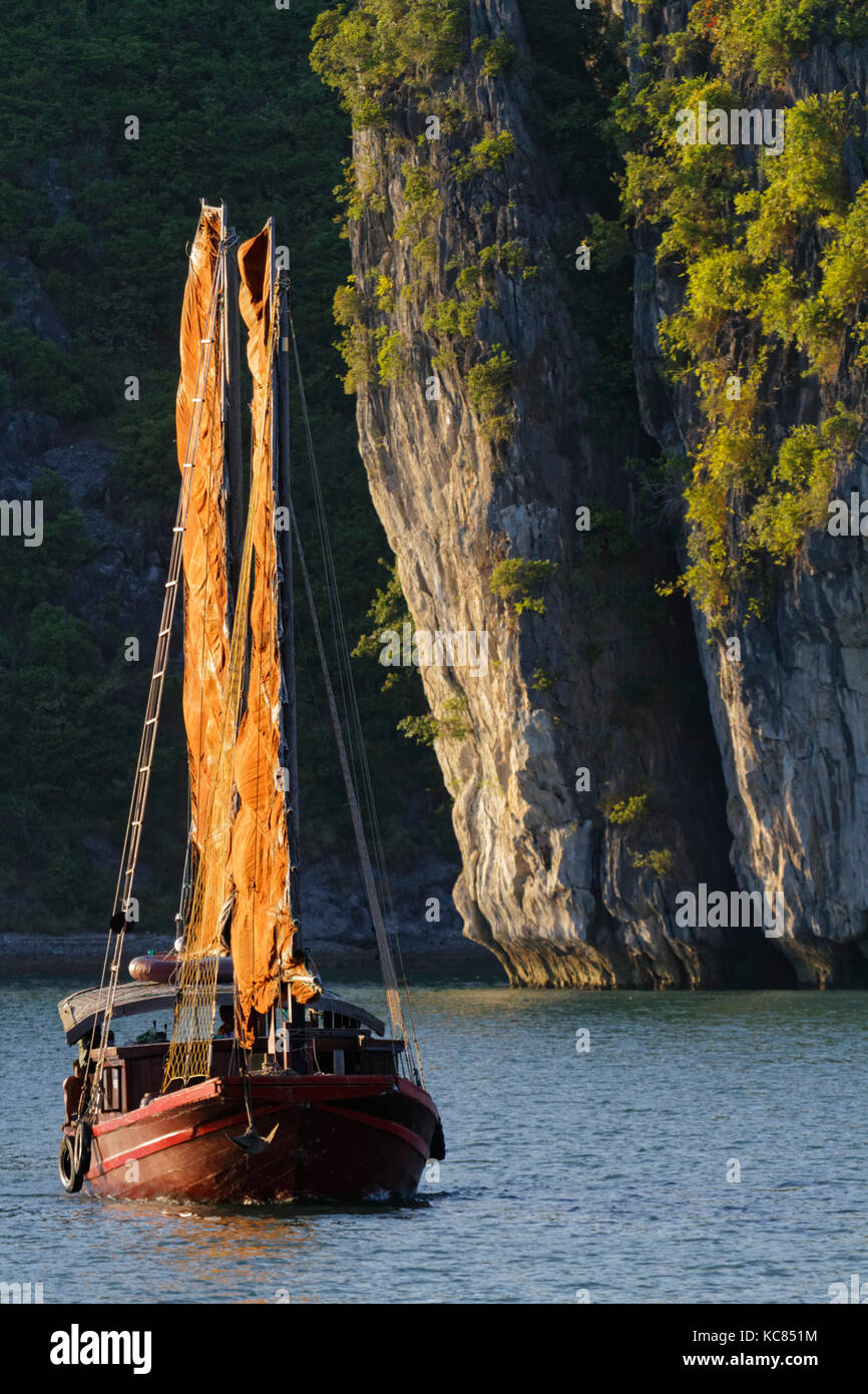CAT BA, VIETNAM, October 27, 2016 : Traditional junk sails in the evening in Cat Ba Archipelago, the southeastern edge of Ha Long Bay. Ha Long Bay has Stock Photo