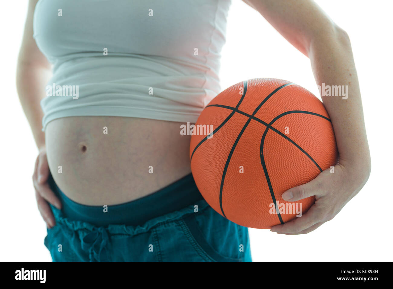 Pregnant woman with basketball isolated on white background Stock Photo