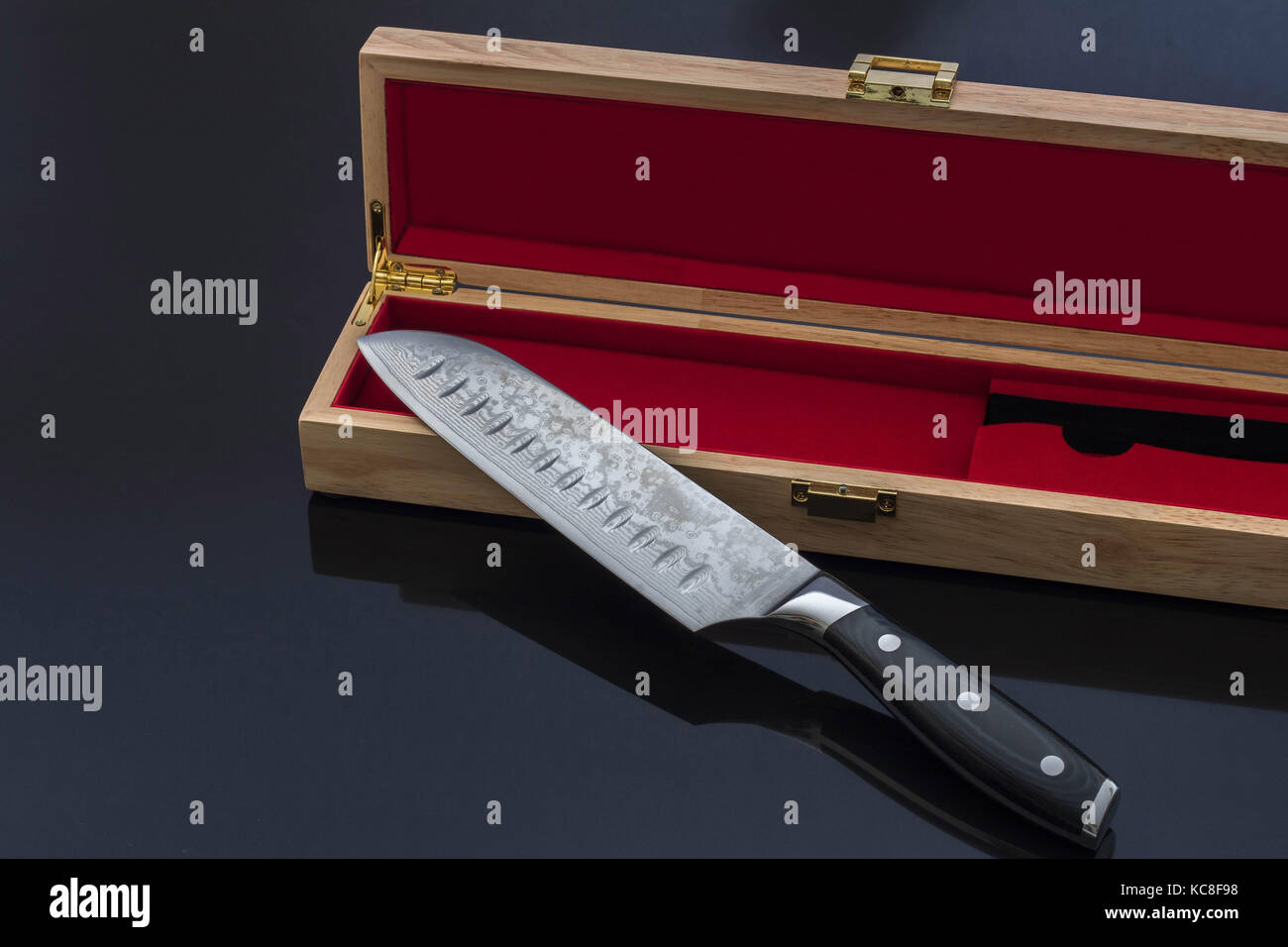 Santoku Kitchen Knife with Elegant Wood Box on Black Reflective Surface Stock Photo
