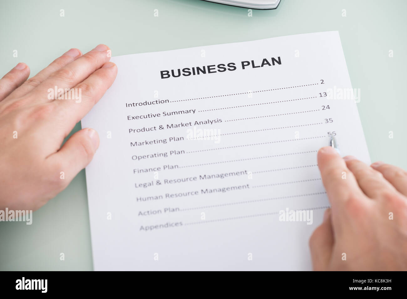 Closeup Of Businessperson Hand Over Business Plan Form Stock Photo