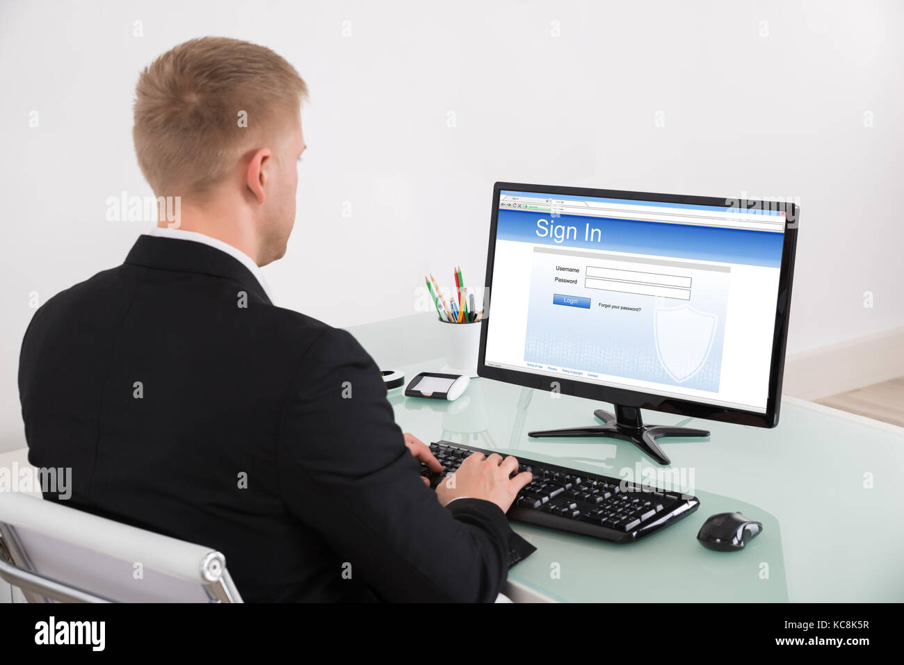 Young Businessman Signing Into Website At Office Stock Photo