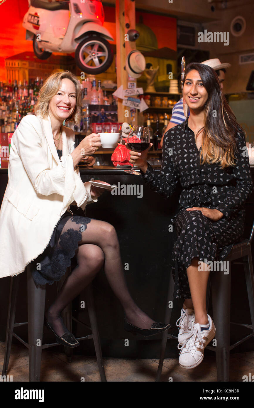 Millennial and a midlifer swapping drinking habits at a local bar in London, UK Stock Photo
