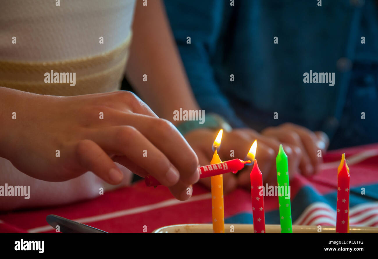 A girl lighting birthday candle on a cake Stock Photo Alamy