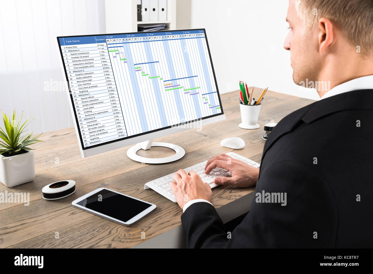 Young Businessman Working On Gantt Chart On Computer At Office Stock Photo
