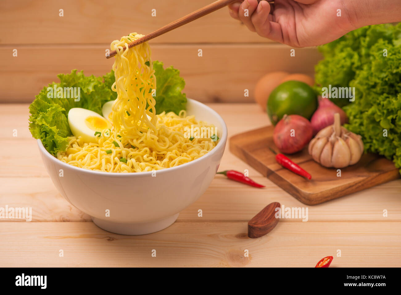 Eating Instant noodles with a wooden chopstick. Stock Photo