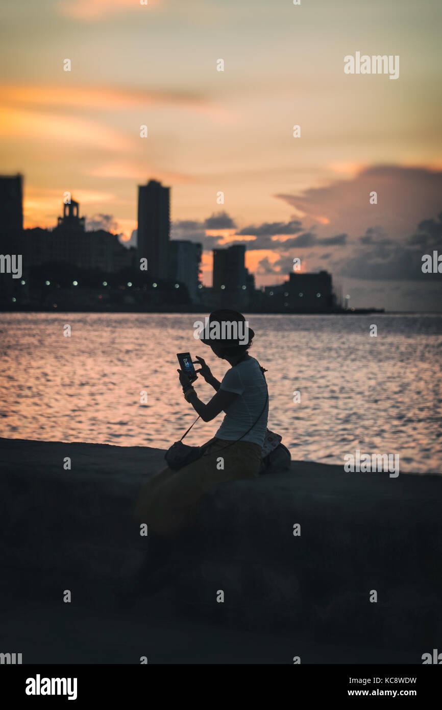 A lone female checks her mobile photography while sitting on The Stock  Photo - Alamy