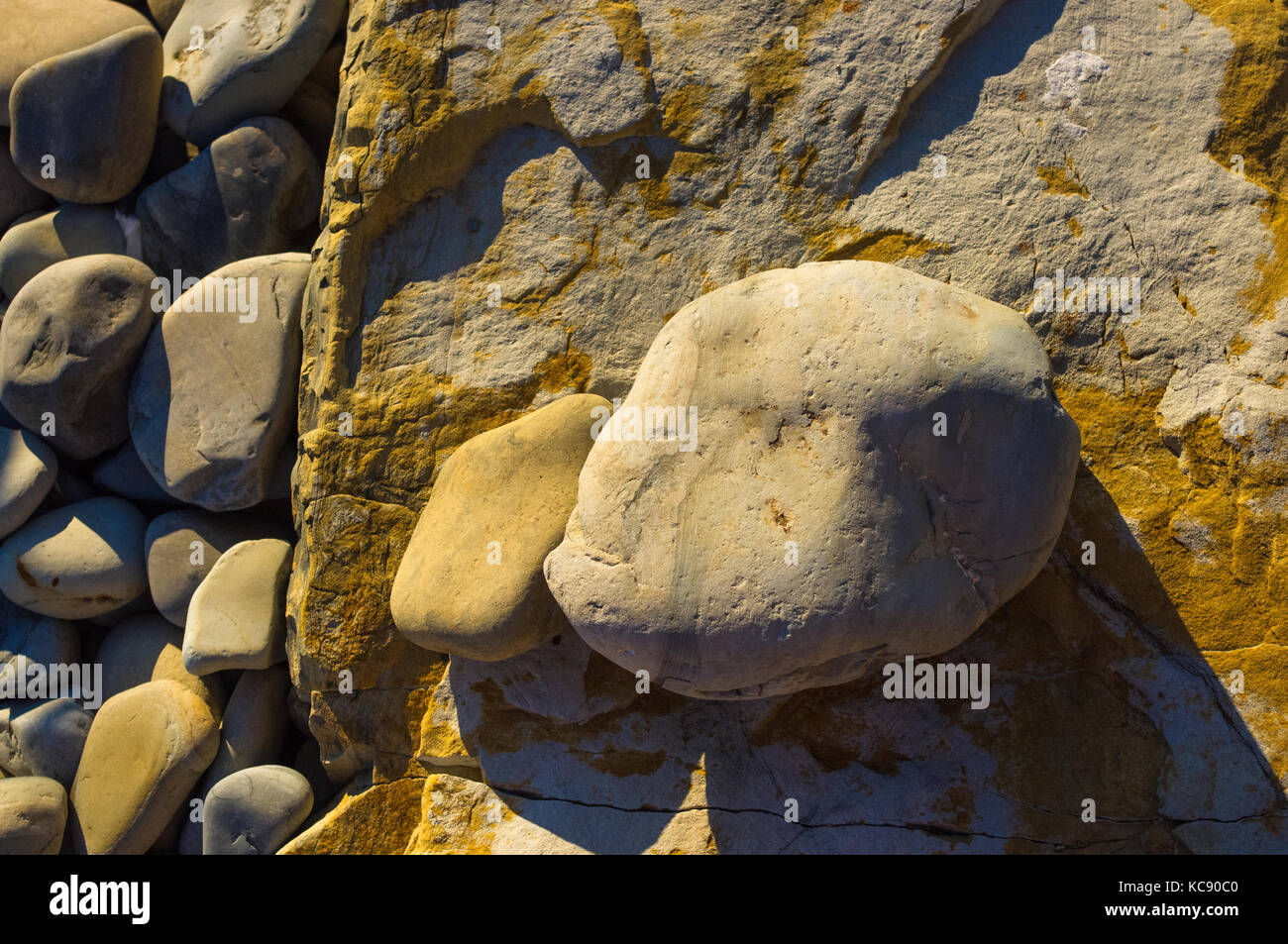 boulders and colorful pebbles on the beach on a warm summer day Stock