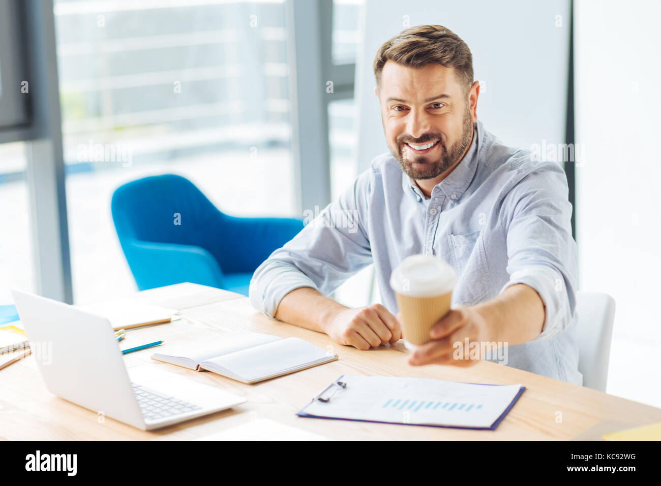 Happy male person demonstrating paper cup Stock Photo - Alamy