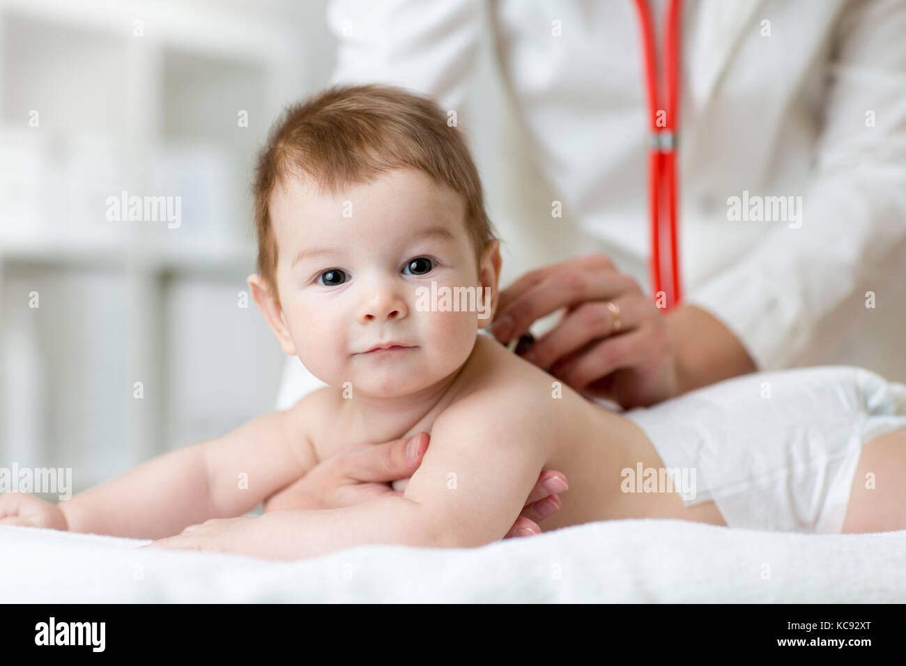 Doctor with newborn baby in hospital background Stock Photo