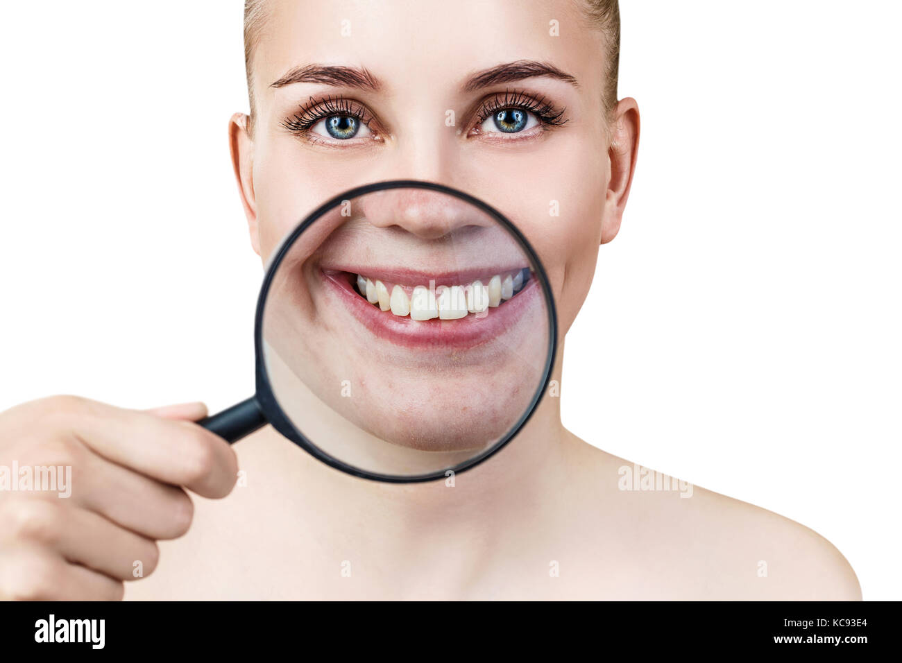 Woman with magnifying glass presents white teeth. Stock Photo