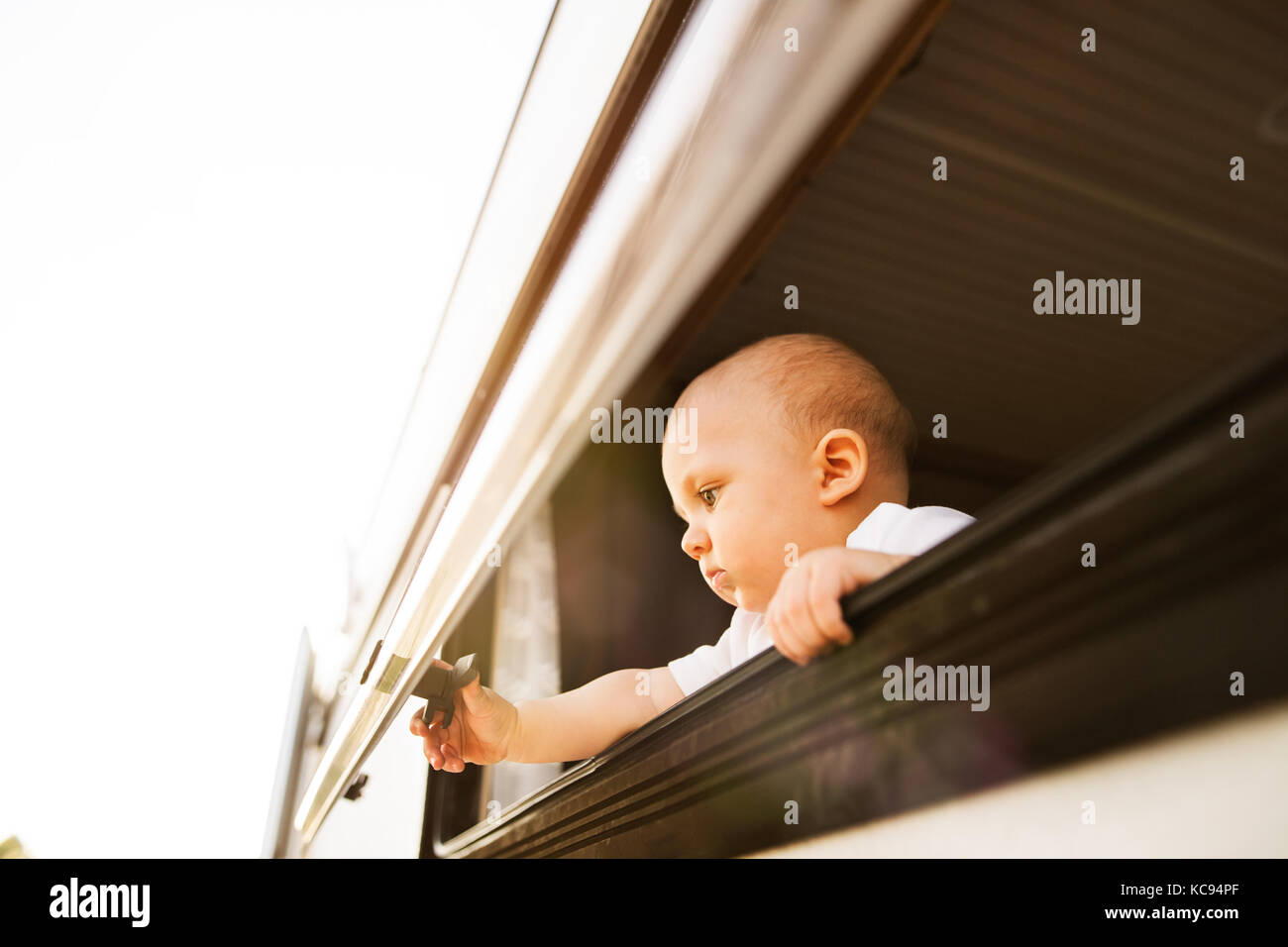 baby boy in a camper van on a summer day. Little boy opening