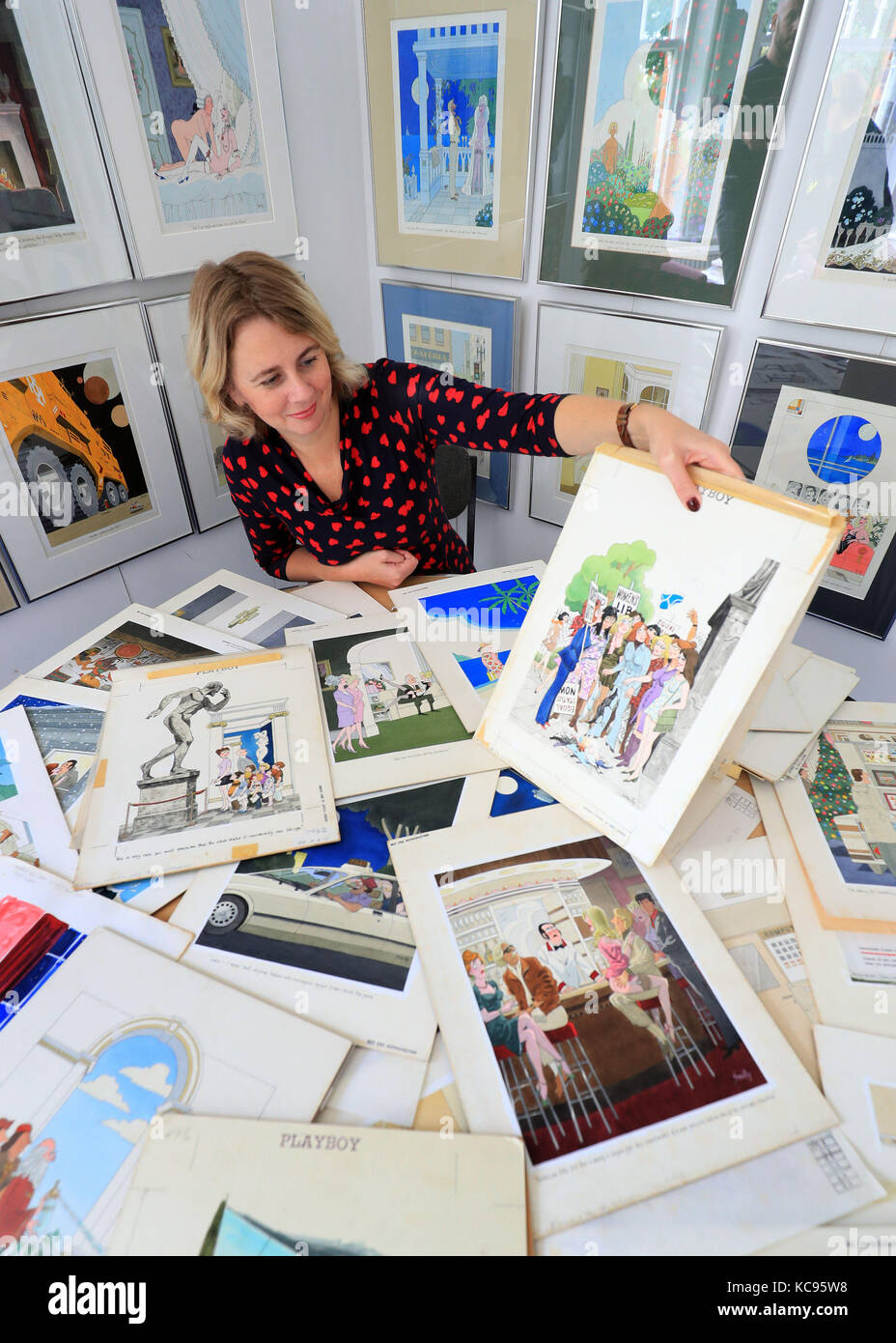 Auctioneer Catherine Southon holds examples from the Smilby cartoon collection, including works that appeared in Playboy, at the Ripley Arts Centre, Bromley, ahead of their auction next month. Stock Photo