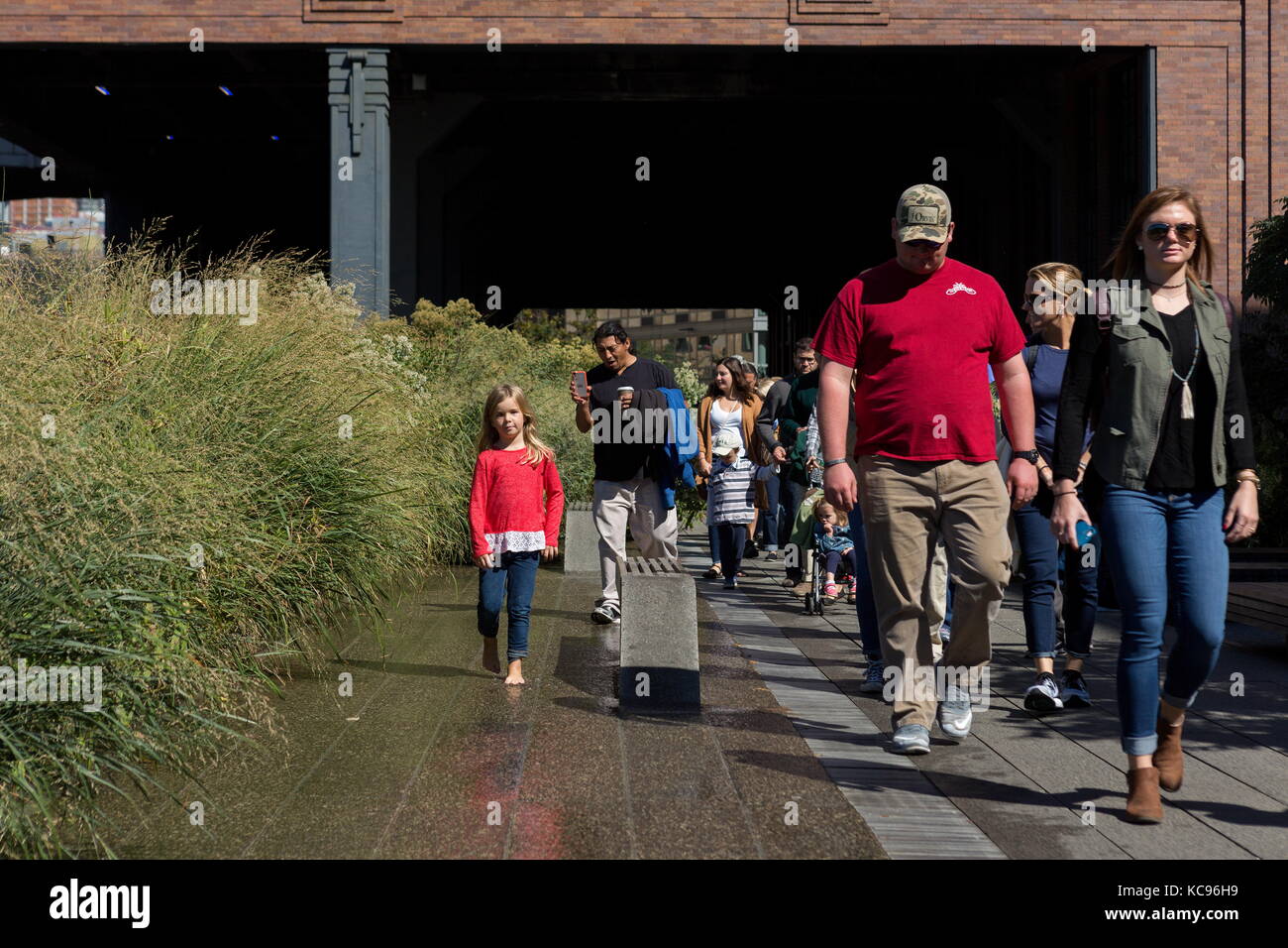 Pedestrians walk along the High Line in New York, New York on October ...