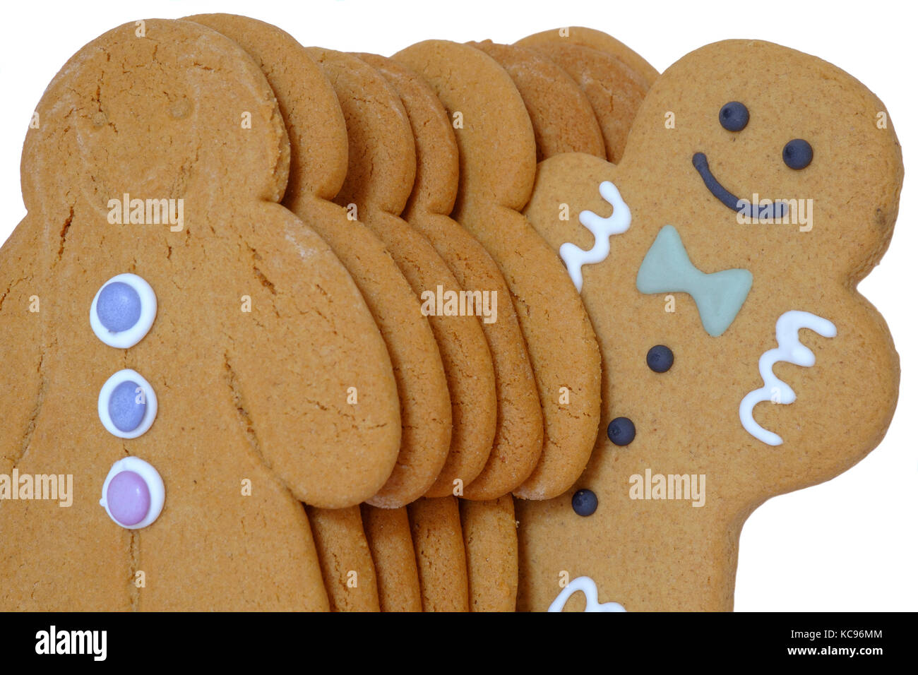 a line up of gingerbread men with one of them standing out of line cut out on white background Stock Photo