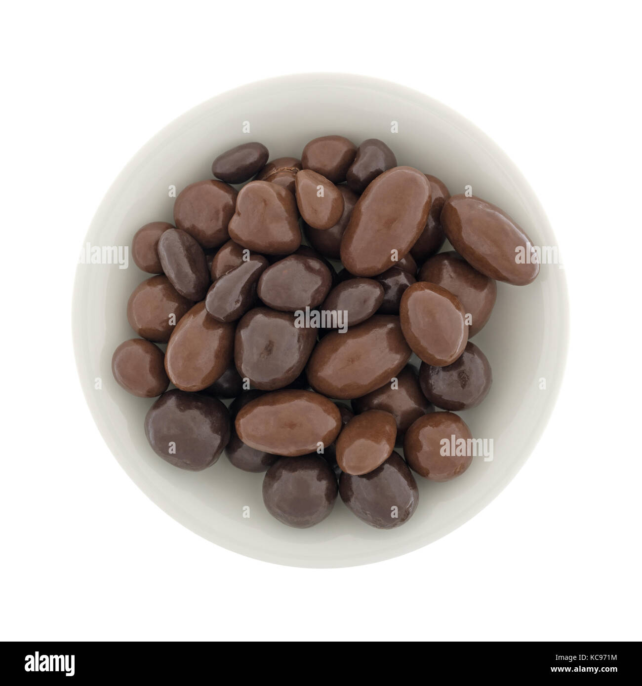 Top view of a bowl filled with bridge mix chocolate candy isolated on a white background. Stock Photo