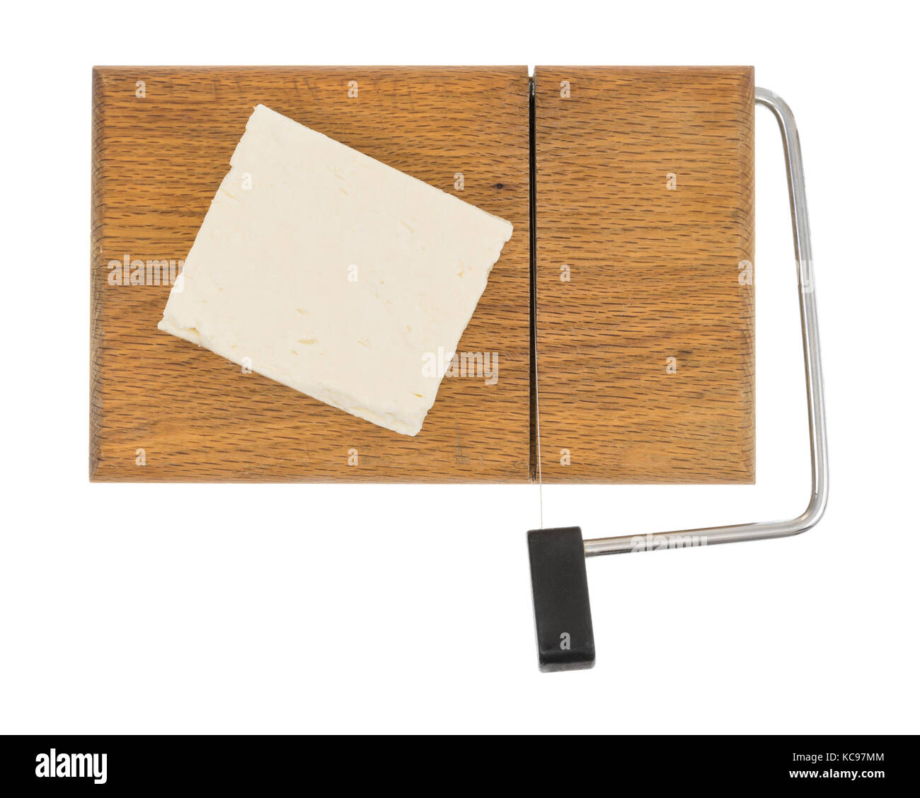 Top view of a block of feta cheese on a wood cheese slicer isolated on a white background. Stock Photo