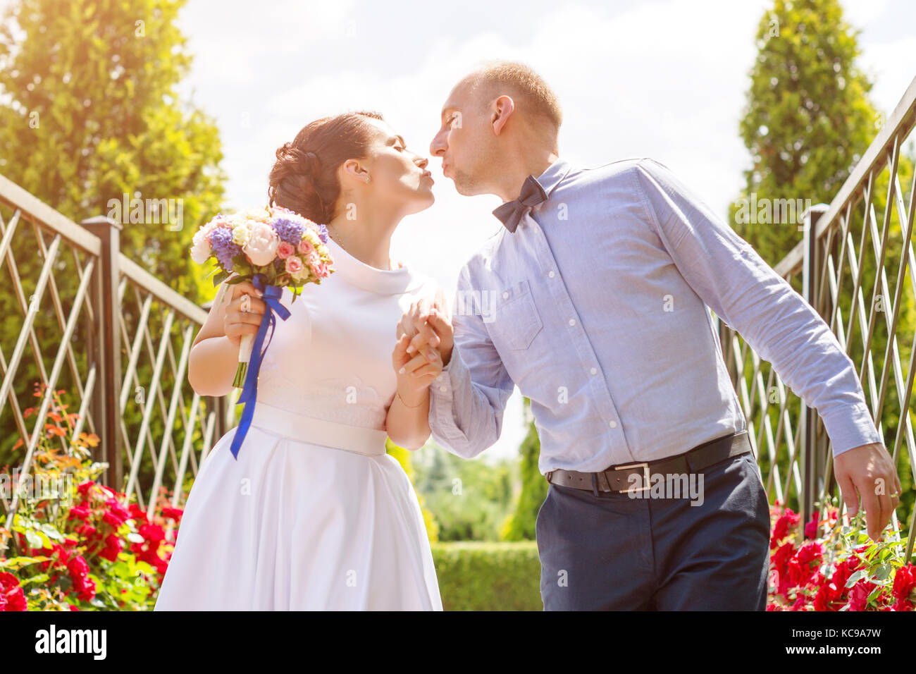 Bride and groom kissing outdoors. Wedding day of happy bridal couple ...