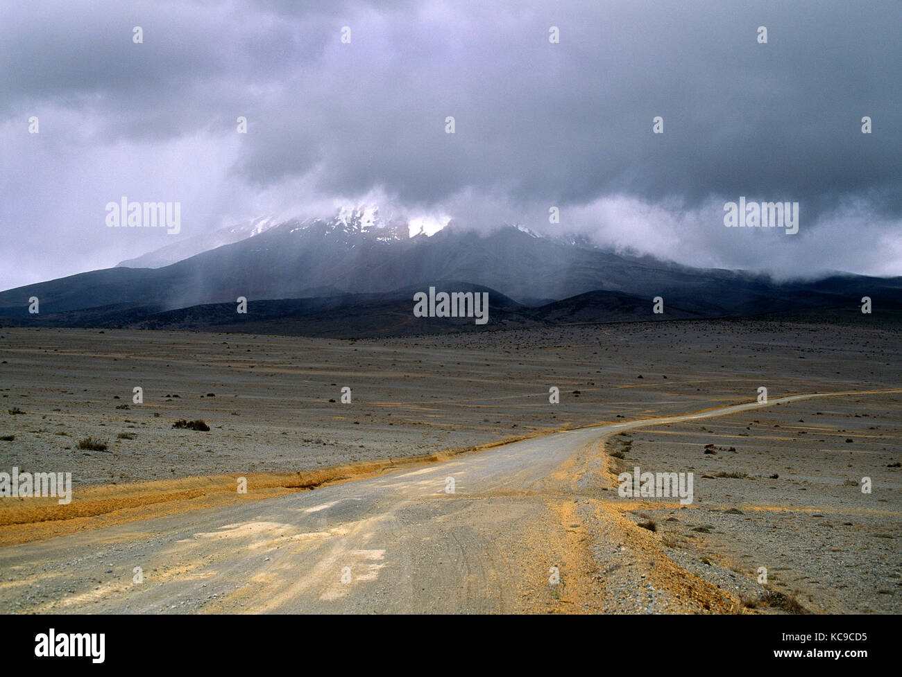 South America. Ecuador. Chimborazo Highlands. Dirt road to mountain shrouded in low cloud. Stock Photo