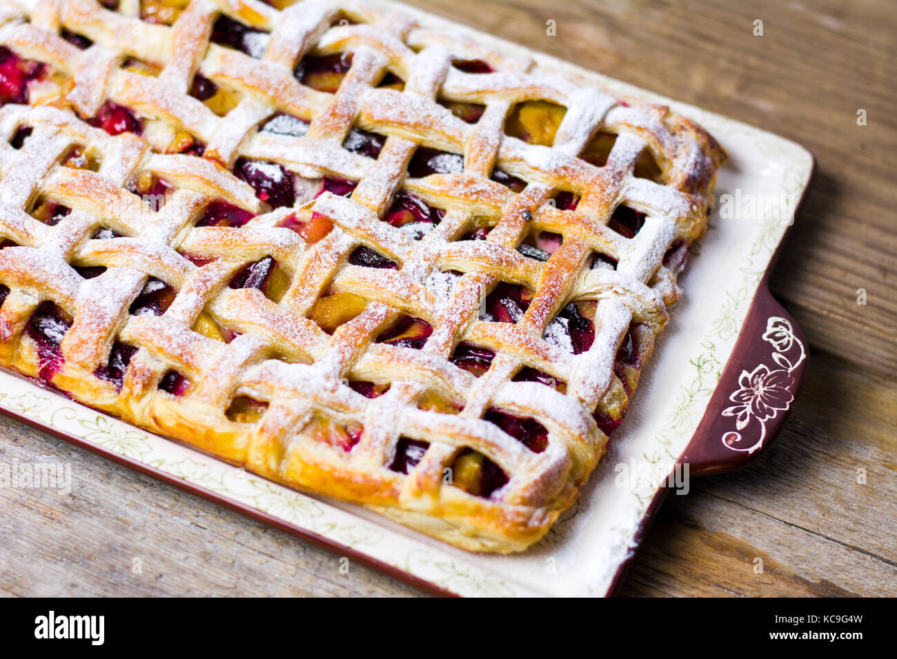 Sweet baked fruit pie with sugar on a tray Stock Photo