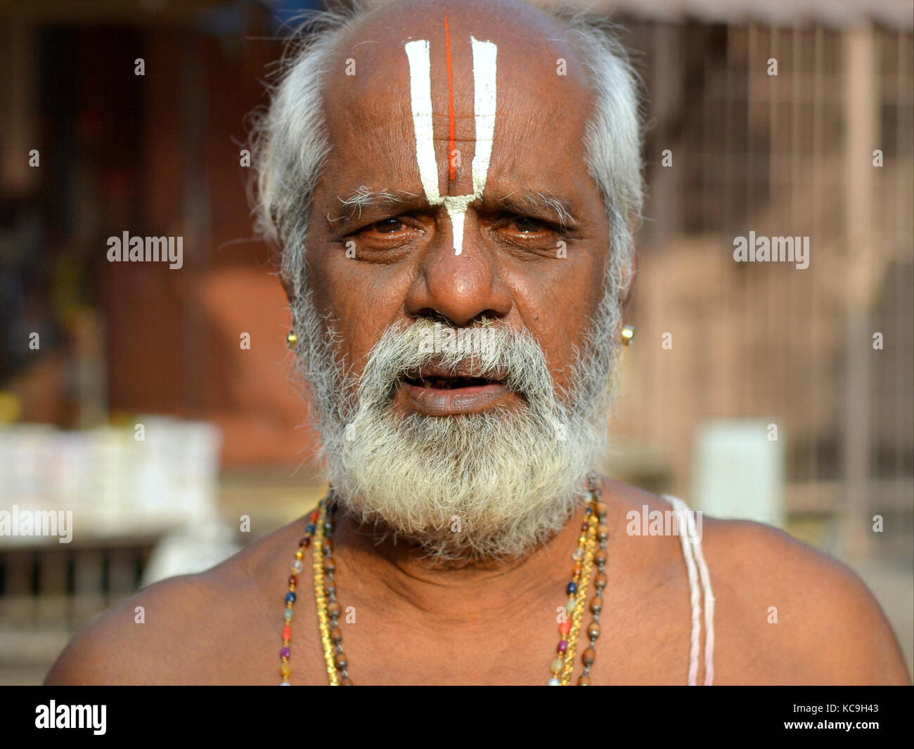 Old Indian Hindu pilgrim (Vaishnavite devotee who worships Vishnu) with distinctive urdhva pundra (U-shaped tilaka mark) on his forehead. Stock Photo